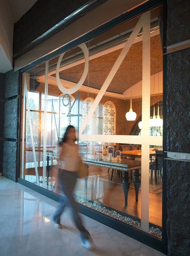 N°4 Restaurant'ın cam cephesi önünden geçen konuk